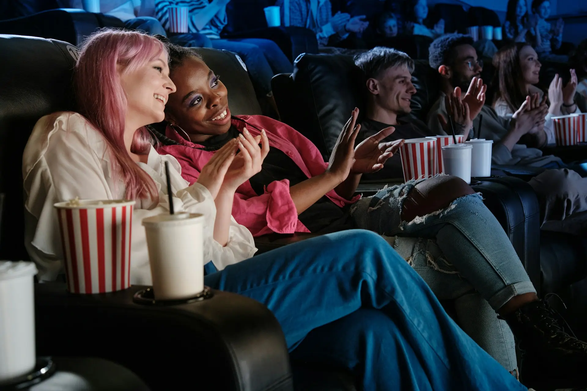 two women sitting at the cinema watching a film